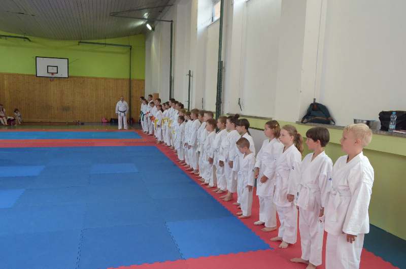Řada dětí v kimonech na tatami při páskování